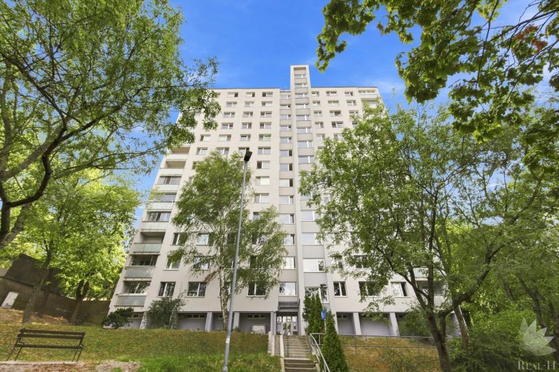 Real - H,s.r.o. ponúka na predaj útulný 2 izbový byt  Bratislava IV  - Bytový dom na Hanulovej ulici v Dúbravke obklopený zeleňou a modrou oblohou.