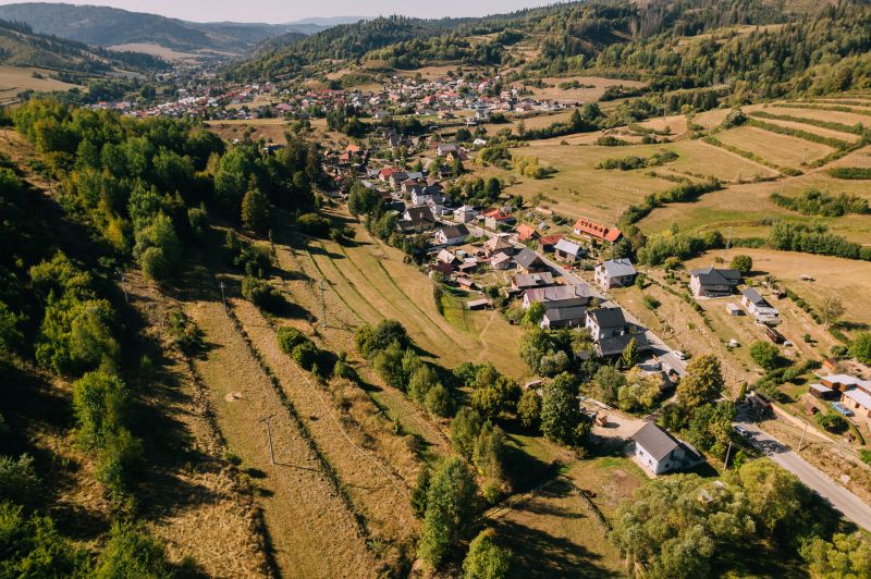 PREDAJ: Pozemky pre rekreačnú chatu, 765 m² – Čierny Balog, Komov - Letecký pohľad na domy a lúky v Čiernom Balogu, Školskej ulici obklopené rekreačnými pozemkami.