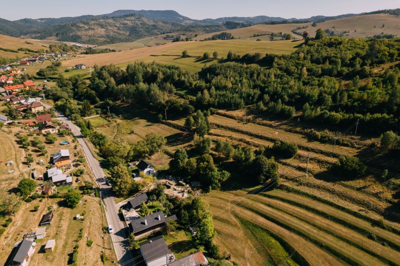 PREDAJ: Pozemky pre rekreačnú chatu, 765 m² – Čierny Balog, Komov - Letecký pohľad na krajinu v Rekreačných pozemkoch, Školská ulica, Čierny Balog, obklopenú zeleňou.