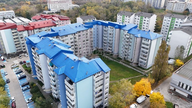 RIVERS | Nebytový priestor v Dúbravke na predaj - Panelové domy s modrými strechami na Agátovej ulici, Bratislava - Dúbravka, obklopené stromami.