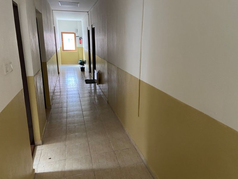 Kancelária na prenájom v centre Rimavskej Soboty za výhodnú cenu - Chodba v kanceláriách s dlažbou a izbovým kvetom pri okne.