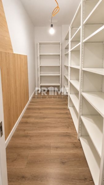 Moderný 2-izbový apartmán, balkón, sklad, Šancová-novostavba PREMIÈRE - Úložný priestor s bielymi regálmi a podlahou s dreveným dekorom v 2-izbovom byte.