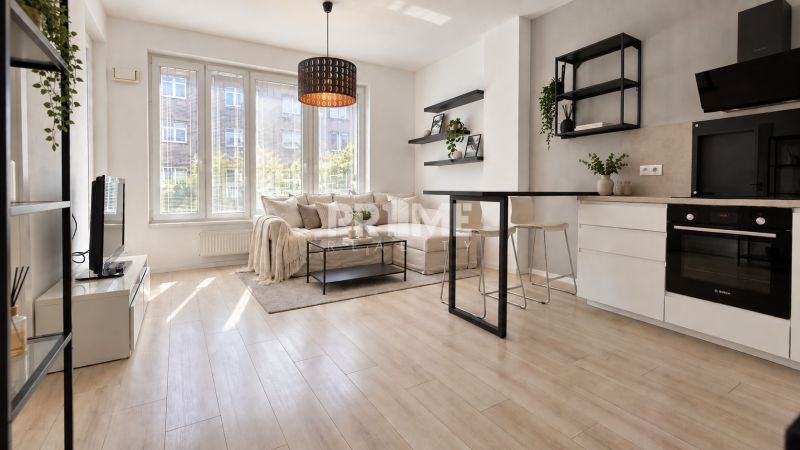 Moderný 2-izbový apartmán, balkón, sklad, Šancová-novostavba PREMIÈRE - Obývacia izba s kuchyňou, sedacou súpravou a podlahou s dreveným dekorom v 2-izbovom byte.