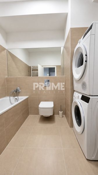 Moderný 2-izbový apartmán, balkón, sklad, Šancová-novostavba PREMIÈRE - Kúpeľňa 2-izbového bytu so sprchou, práčkou, sušičkou a béžovým obkladom.