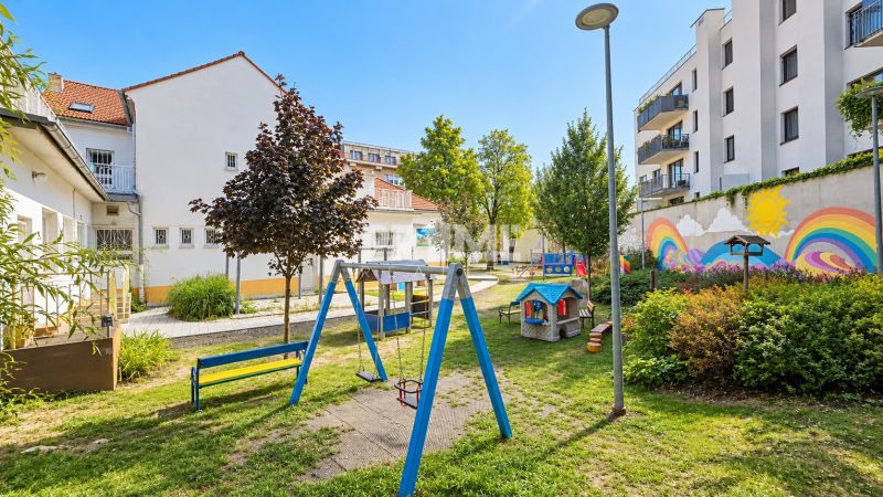 Moderný 2-izbový apartmán, balkón, sklad, Šancová-novostavba PREMIÈRE - Detské ihrisko obklopené budovami s farebnými nástennými maľbami na Sancovej ulici.