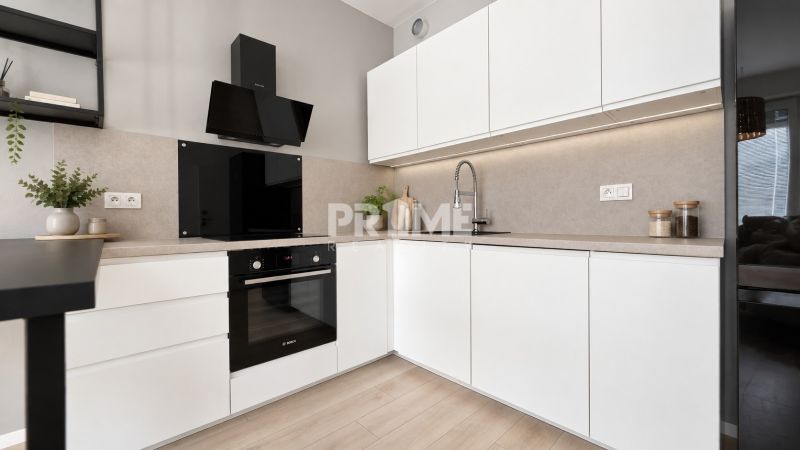 Moderný 2-izbový apartmán, balkón, sklad, Šancová-novostavba PREMIÈRE - Kuchyňa v 2-izbovom byte s bielymi skrinkami a podlahou s dreveným dekorom.