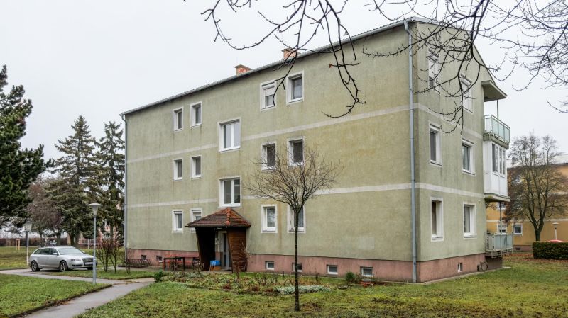 I Na predaj 2-i byt s terasou v Auersthal (Rakúsko) - Budova na ulici Kirchssen v Auersthali, obklopená zeleňou a parkovaním.
