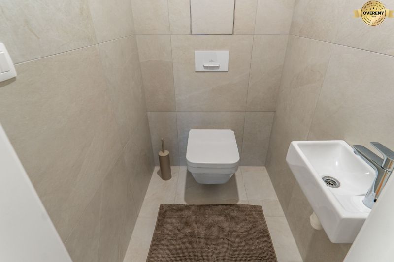 I Projekt Rezidencia MIEROVA - Toaleta so závesným WC, malým umývadlom a béžovou dlažbou, Výstavba bytov.