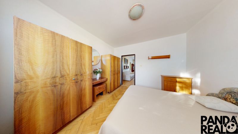 3.izbový byt so záhradou /420 m²/ a chatkou BOŠANY - Spálňa v 3-izbovom byte s nábytkom a podlahou s dreveným dekorom.
