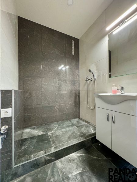 3.izbový byt so záhradou /420 m²/ a chatkou BOŠANY - Kúpeľňa v 3-izbovom byte so sprchovým kútom a tmavými dlaždicami.