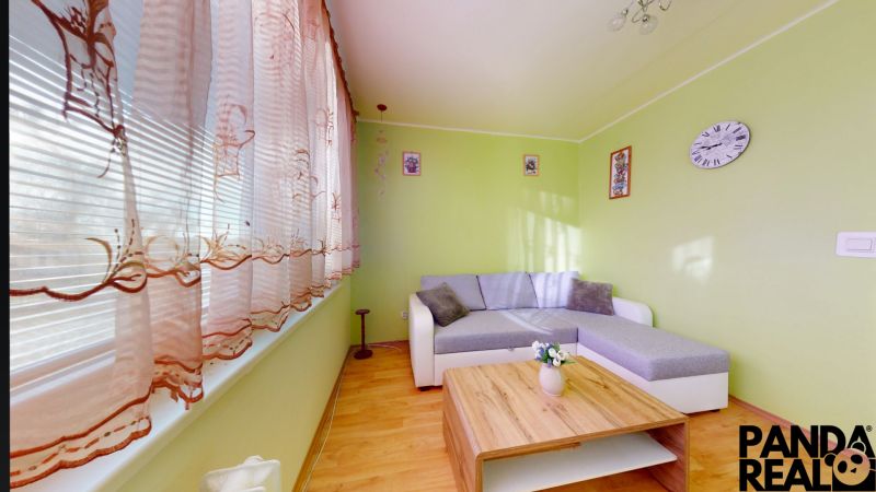 3.izbový byt so záhradou /420 m²/ a chatkou BOŠANY - Obývacia izba s podlahou s dreveným dekorom a zelenými stenami v 3-izbovom byte.