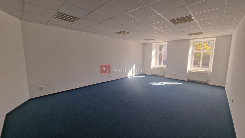 Prenájom - Poprad, kancelárske priestory centrum, 38 m2 - Svetlá priestranná kancelária s modrým kobercom a bielymi stenami.