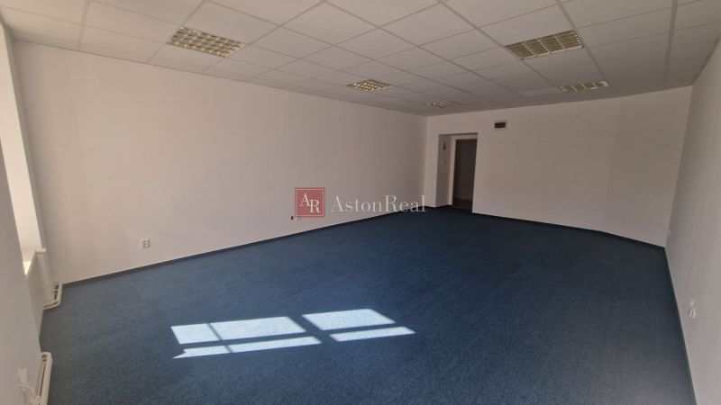 Prenájom - Poprad, kancelárske priestory centrum, 38 m2 - Kancelárie s modrým kobercom, bielymi stenami a stropnými svetlami.