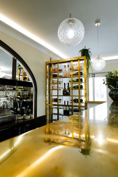 Jedinečná príležitosť - reštaurácia s kompletným konceptom a zázemím - Elegantná vinotéka a bar v obchodných priestoroch s moderným osvetlením a zlatými detailmi.