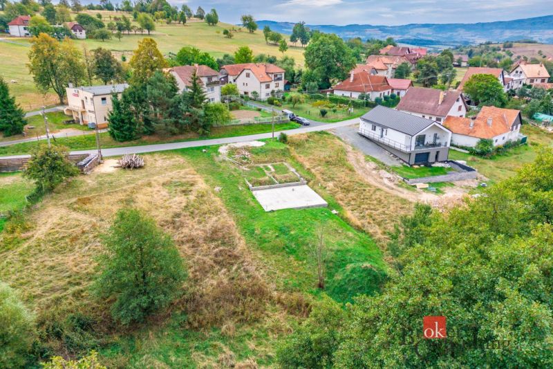 Pozemok na predaj v Detve, Skliarovo, aj so základovou platňou - Pozemky - bývanie v Detve s výhľadom na okolité domy a prírodnú scenériu.