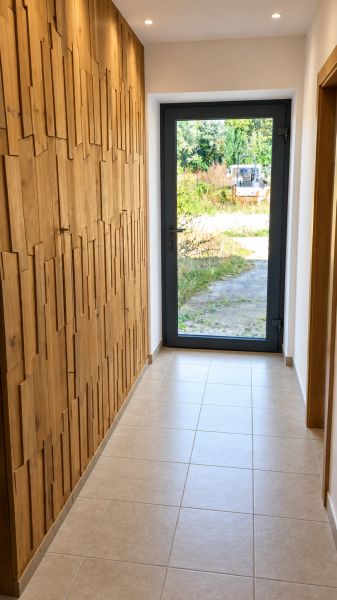 MODERNÝ 6-IZBOVÝ BUNGALOV S TERASOU A POZEMKOM 884 m² – RATNOVCE - Chodba v rodinnom dome s drevenými prvkami na stene a presklenými dverami.
