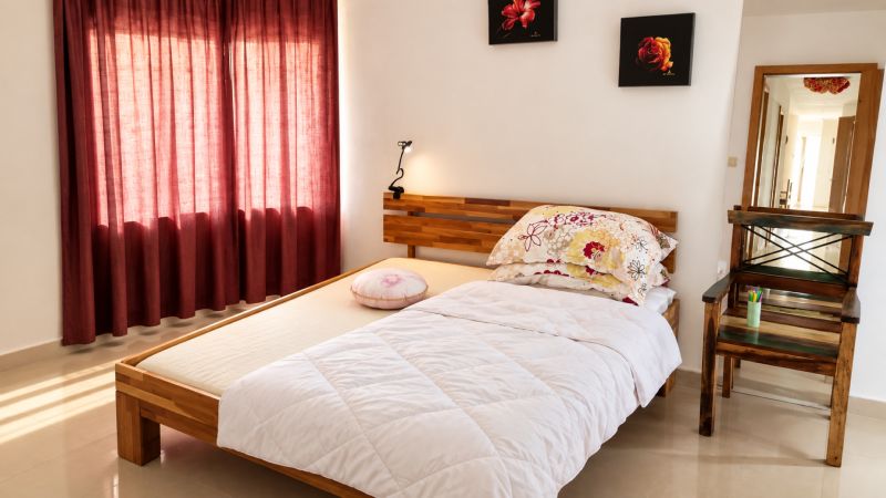 MODERNÝ 6-IZBOVÝ BUNGALOV S TERASOU A POZEMKOM 884 m² – RATNOVCE - Svetlá spálňa s posteľou, zrkadlom a červenými závesmi v Rodinnom dome.