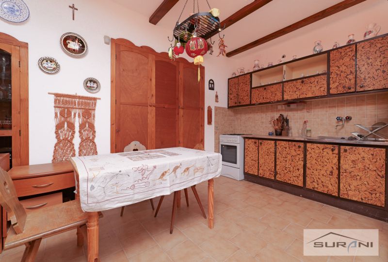 Starší rodinný dom s veľkou záhradou v obci Štefanová | okres Pezinok - Kuchyňa v rodinnom dome s rustikálnym dekorom a nástennými dekoráciami nad stolom.