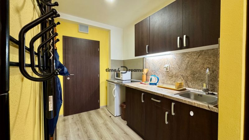 NA PREDAJ apartmán v Podhájskej  - Kuchynský kút v Rekreačnom apartmáne s podlahou s dreveným dekorom a skrinkami.