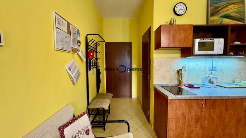 NA PREDAJ investičný apartmán v Podhájskej - Interiér Rekreačného apartmánu s kuchynkou, mikrovlnkou, vešiakom a nástennými dekoráciami.