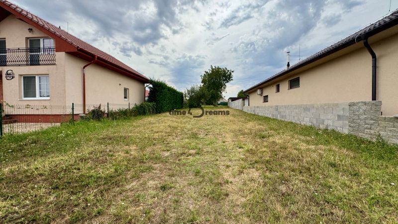 NA PREDAJ stavebný pozemok Močenok - Pozemok na bývanie v Močenku medzi rodinnými domami s trávnatým porastom.