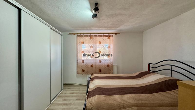 NA PREDAJ rodinný dom v meste Šurany - Spálňa v rodinnom dome s podlahou s dreveným dekorom a skriňou.