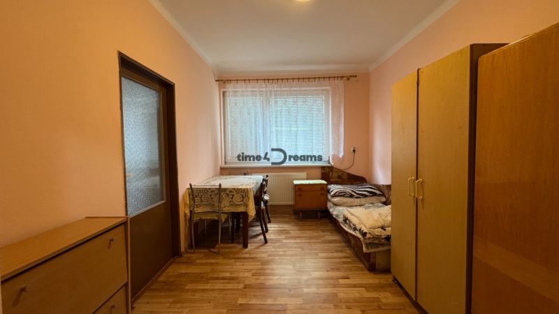 NA PREDAJ Rodinný dom - Šurany - Nitriansky Hrádok, EXKLUZÍVNE - Izba v rodinnom dome so stolom, stoličkami, posteľou a skriňou.