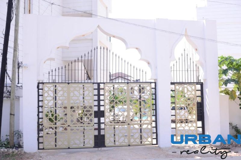2-IZBOVÝ CONDO APARTMÁN PRI PLÁŽI, MBWENI, ZANZIBAR - Vstupná brána pri 2-izbovom byte na ulici Mbweni v Zanzibare s dekoratívnymi kovovými prvkami.