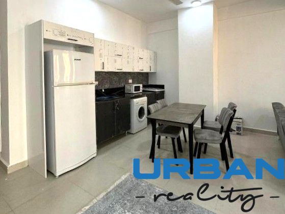 2-IZBOVÝ CONDO APARTMÁN PRI PLÁŽI, MBWENI, ZANZIBAR - Kuchyňa v 2-izbovom byte s jedálenským stolom, chladničkou a pračkou.