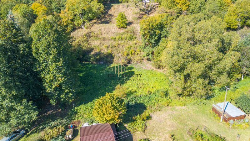 Predaj, rekreačné pozemky Štiavnické Bane - Letecká snímka rekreačných pozemkov v Štiavnických Baniach obklopená hustými lesmi.