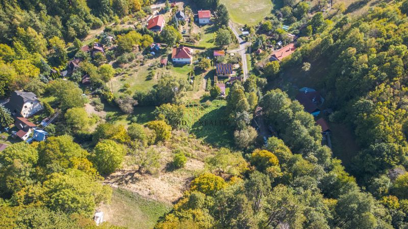 Predaj, rekreačné pozemky Štiavnické Bane - Letecký pohľad na rozmanité rekreačné pozemky v Štiavnických Baniach obklopené zeleňou.