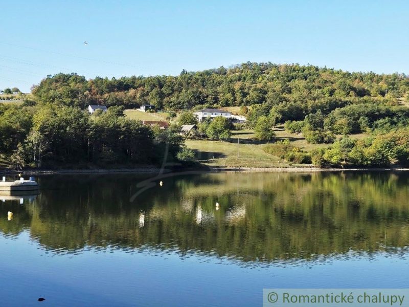 3106m2 stavebný pozemok nad priehradou v Krupine - Pohľad na rybník so stromami a kopcami v Záhradách v Krupine.