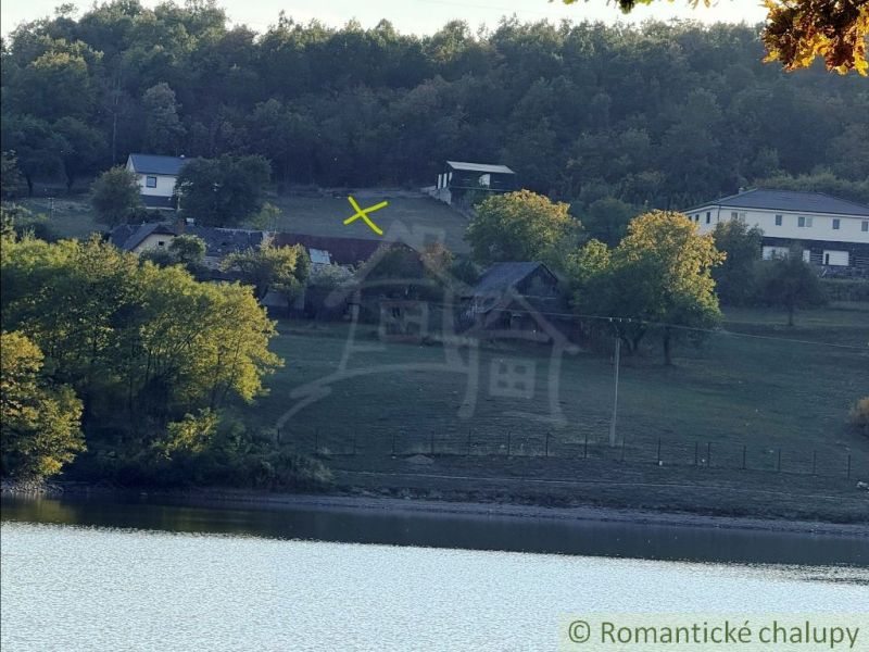 3106m2 stavebný pozemok nad priehradou v Krupine - Pohľad na vidiecku krajinu a jezero v okolí Krupiny so záhradami a domami.