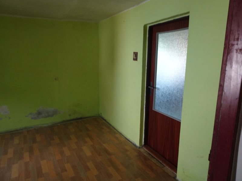 Na predaj rodinný dom Diviaky nad Nitricou - Izba v rodinnom dome s drevenou podlahou a zelenými stenami.