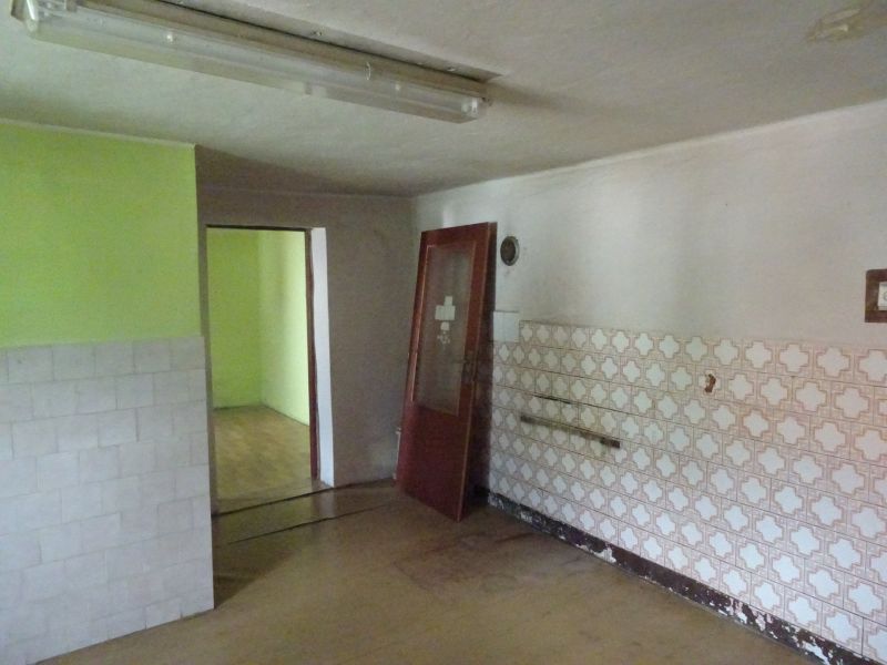 Na predaj rodinný dom Diviaky nad Nitricou - Interiér rodinného domu s obkladom na stene a zelenou stenou v pozadí.