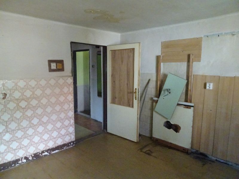 Na predaj rodinný dom Diviaky nad Nitricou - Interiér rodinného domu s opotrebovanými obkladmi a dverami na vidieku.