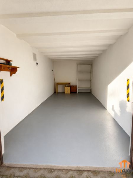 PRENÁJOM - Murovaná garáž 18 m² –  Nitra - Prázdna garáž s regálom a stolom na Schurmannovej ulici v Nitre.