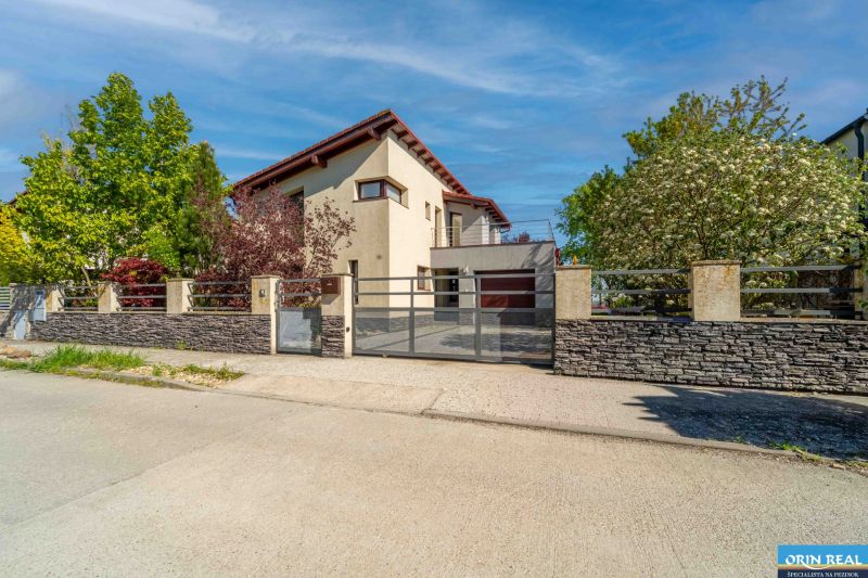 PRENÁJOM ZARIADENÉHO 4 IZB.RD V PEZINKU POD LESOM - Rodinný dom na ulici Javorová v Pezinku s kamenným plotom a zelení v záhrade.