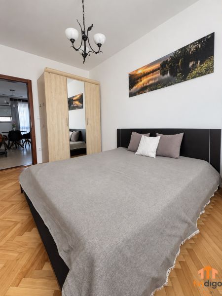 PRENÁJOM - 3-izbový zariadený byt s balkónom a garážou - Šustekova - Spálňa s veľkou posteľou, šatníkovou skriňou a podlahou s dreveným dekorom v 3-izbovom byte.