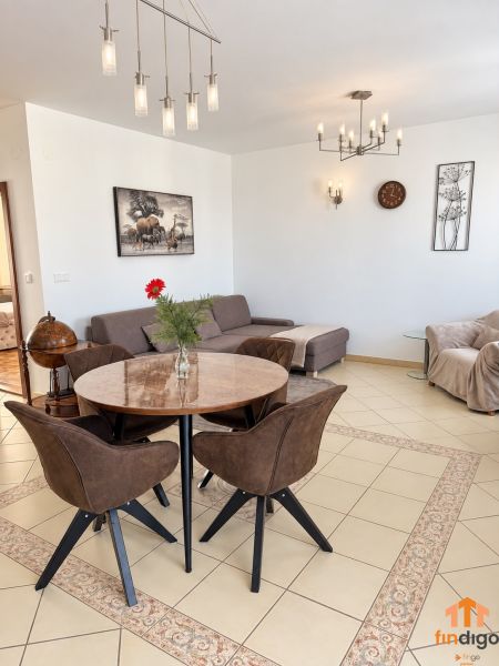 PRENÁJOM - 3-izbový zariadený byt s balkónom a garážou - Šustekova - Obývacia izba v 3-izbovom byte s elegantným osvetlením a jedálenským stolom.