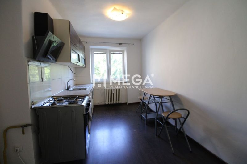 NA PRENÁJOM - Veľký 2 izbový byt, nezariadený, Sídlisko 1, Humenné - Kuchyňa v 2-izbovom byte s podlahou s dreveným dekorom a jedálenským stolom.