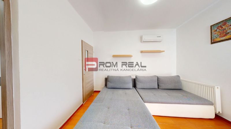 6i DVOJGENERAČNÝ DOM PO REKONŠTRUKCII S VEĽKÝM POZEMKOM A SMARTHOME –  - Obývacia izba s pohovkou, poličkami a klimatizáciou v rodinnom dome na terakotovej podlahe.