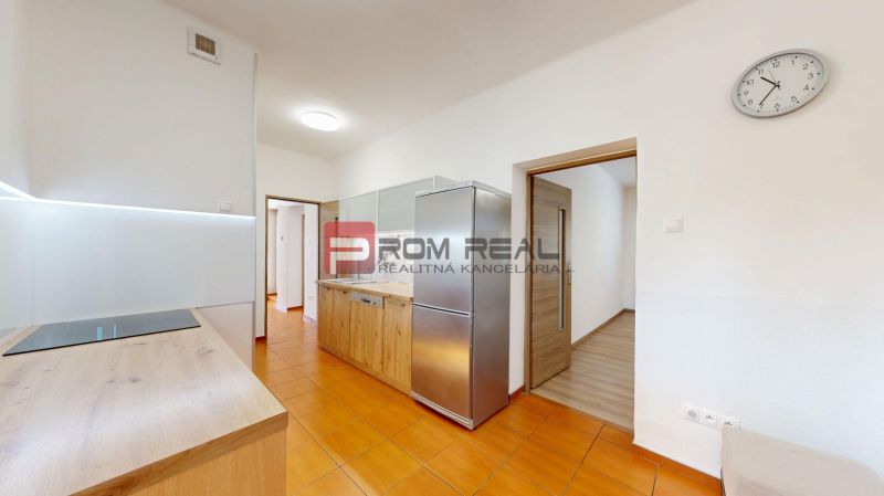 6i DVOJGENERAČNÝ DOM PO REKONŠTRUKCII S VEĽKÝM POZEMKOM A SMARTHOME –  - Kuchyňa v rodinnom dome s bielymi stenami, oranžovou podlahou a nerezovou chladničkou.