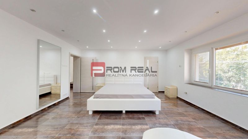 6i DVOJGENERAČNÝ DOM PO REKONŠTRUKCII S VEĽKÝM POZEMKOM A SMARTHOME –  - Priestranná svetlá spálňa s veľkou posteľou a oknom v rodinnom dome.