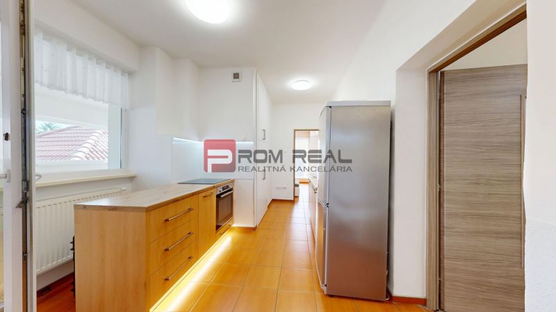 6i DVOJGENERAČNÝ DOM PO REKONŠTRUKCII S VEĽKÝM POZEMKOM A SMARTHOME –  - Svetlá kuchyňa s dreveným dekorom a nerezovou chladničkou v rodinnom dome.