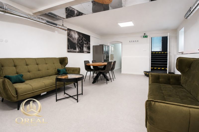 **Hotový priestor. Povolené ubytovanie. Pripravené zarábať**Airbnb** - Obývacia izba s olivovo zelenou sedačkou a moderným nábytkom vo veľkom byte.