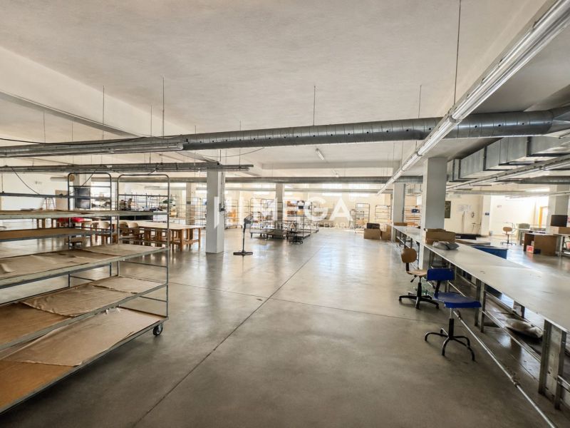 NA PREDAJ MODERNÝ VÝROBNO-SKLADOVACÍ AREÁL V SNINE - Priestranné obchodné priestory s minimalistickým zariadením a kovovými regálmi.
