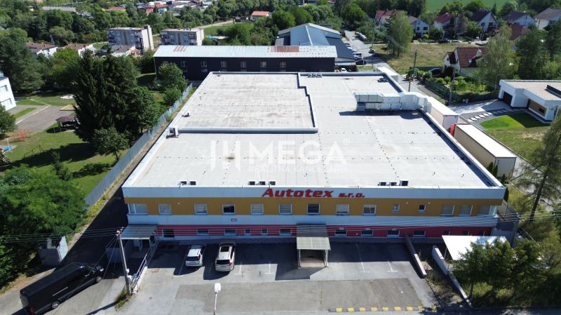 NA PREDAJ MODERNÝ VÝROBNO-SKLADOVACÍ AREÁL V SNINE - Budova obchodných priestorov na Perečínskej ulici v Snine obklopená zeleňou.