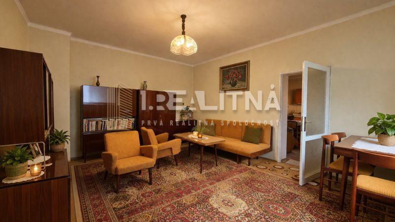 RODINNÝ DOM S VÝNIMOČNOU ZÁHRADOU, 1 141 M², BANSKÁ BYSTRICA  - Obývacia izba v rodinnom dome s retro nábytkom a orientálnym kobercom.