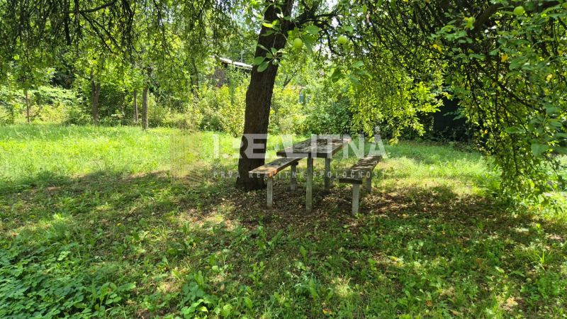RODINNÝ DOM S VÝNIMOČNOU ZÁHRADOU, 1 141 M², BANSKÁ BYSTRICA  - Záhrada s lavičkou a stolom pod stromom na Jakubskej ceste v Banskej Bystrici.